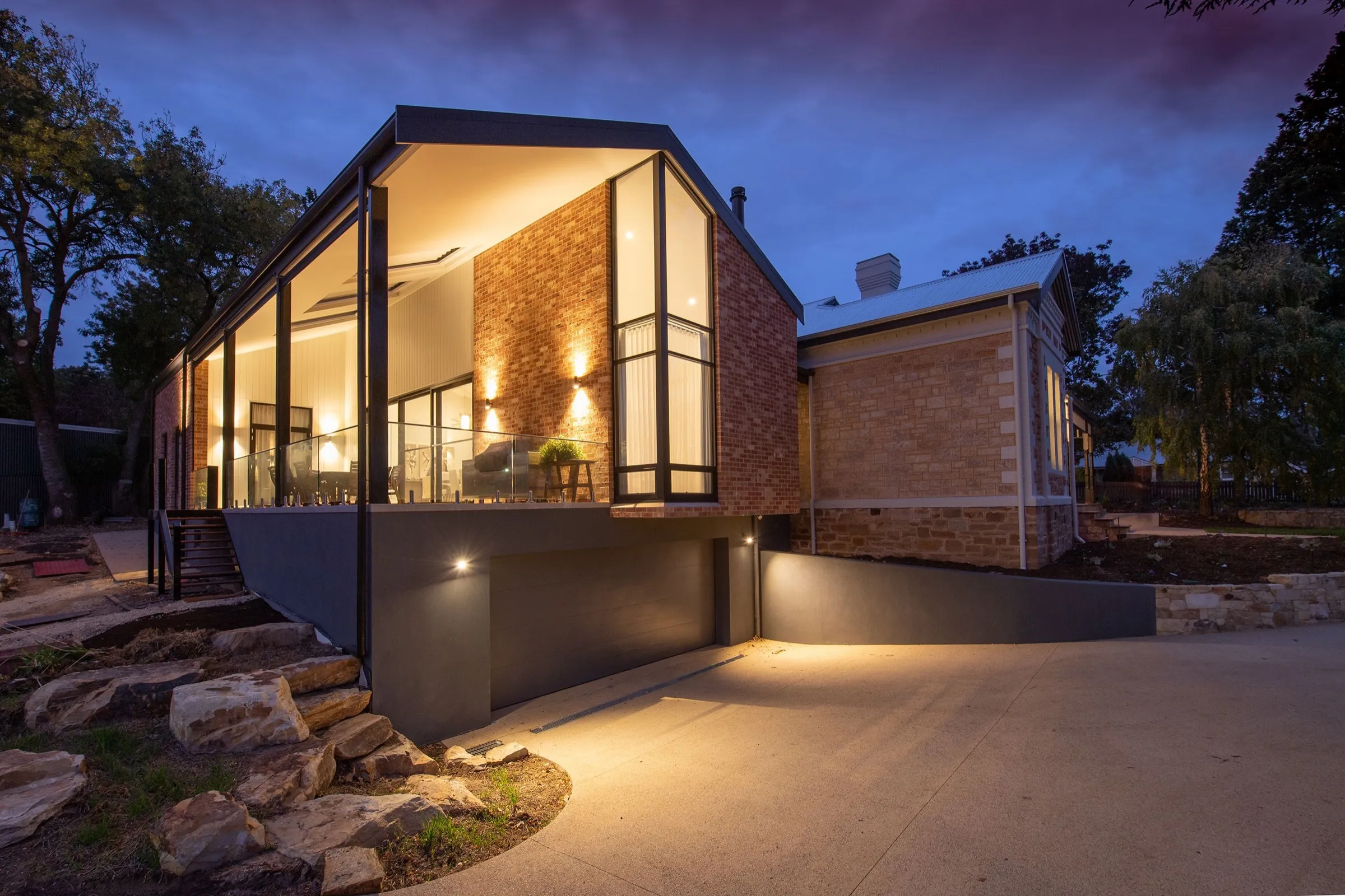 Brick and glass gabled house at blue hour